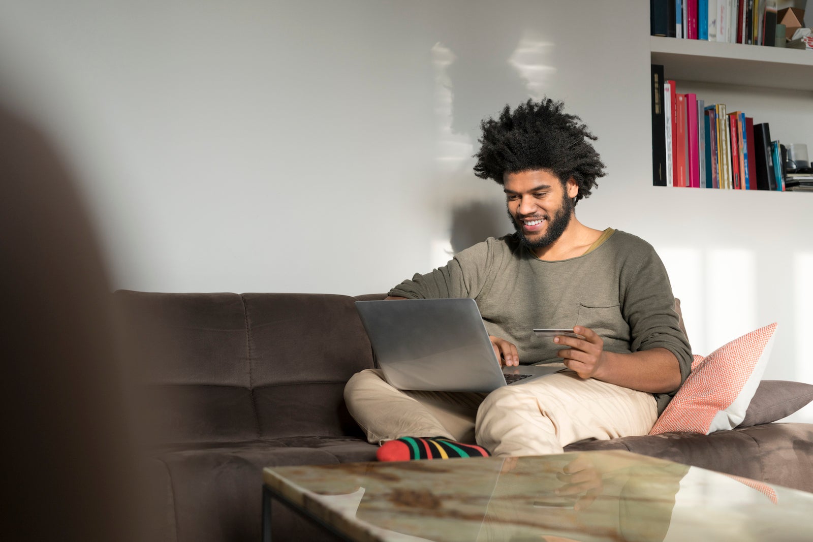 A man uses a laptop while sitting in his living room