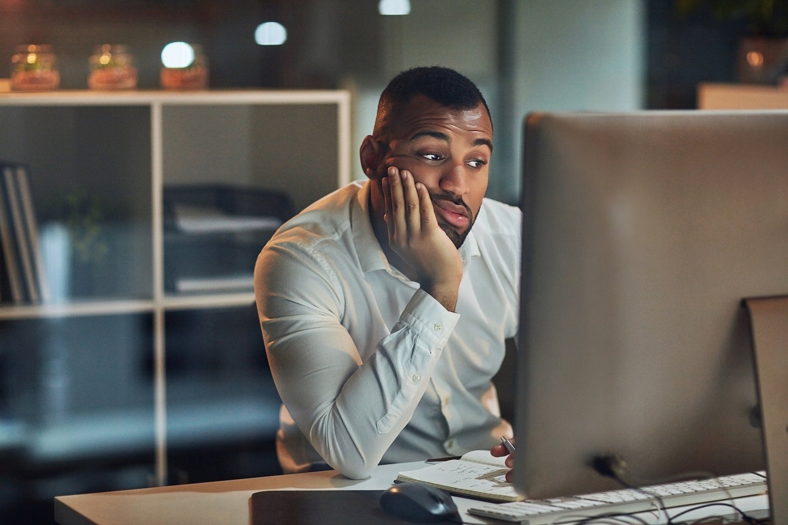 a person looks frustrated while staring at a computer screen