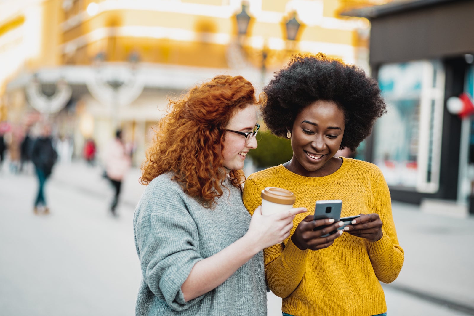 2 friends look at a smartphone together