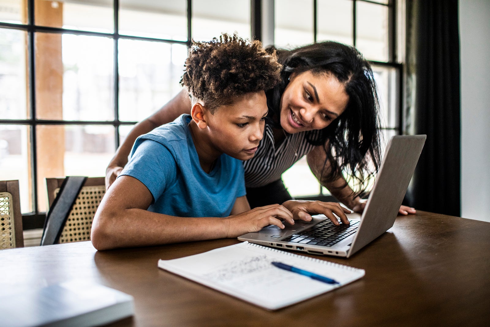 a parent and child look at information together on a laptop