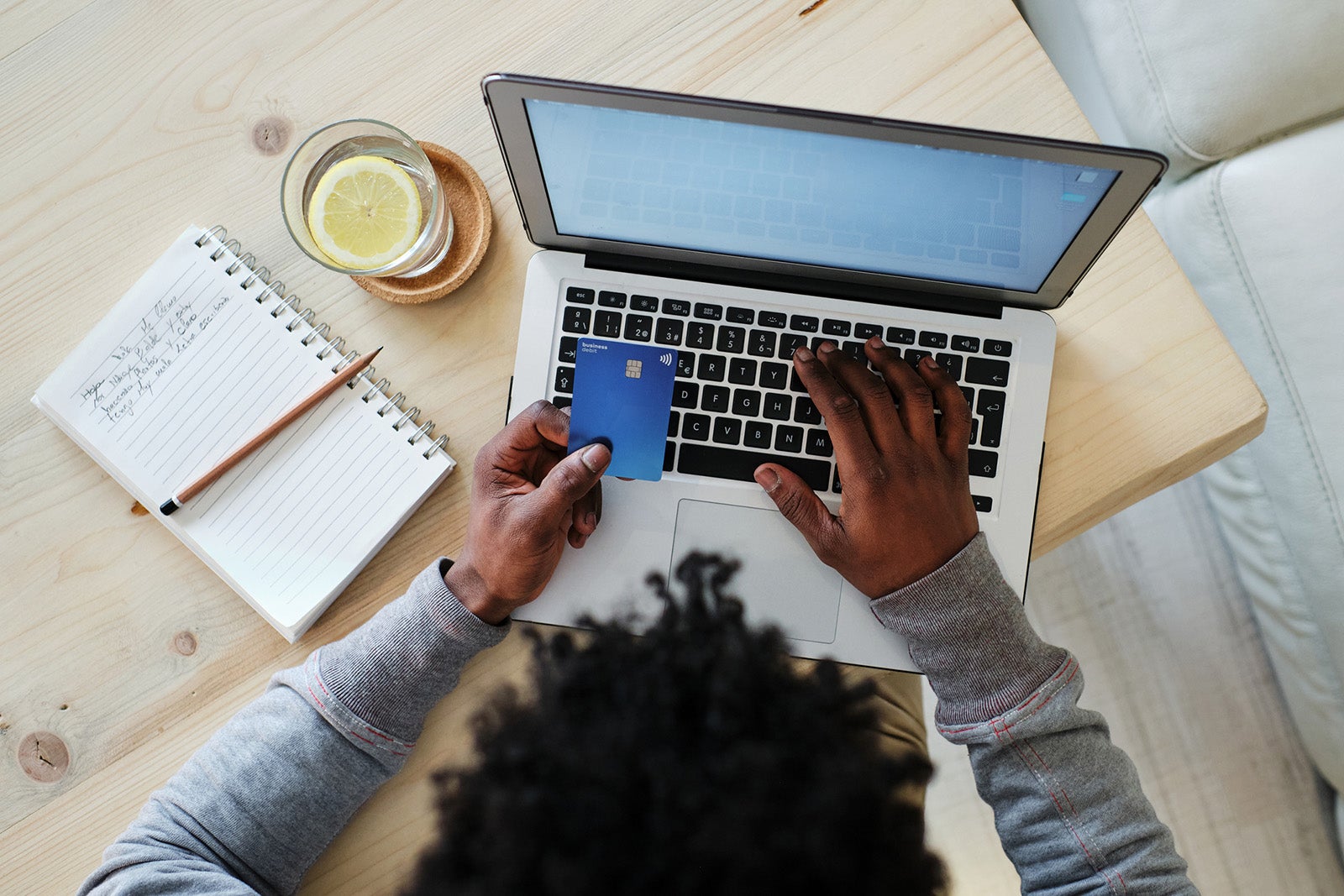 Man using computer with a credit card in his hand