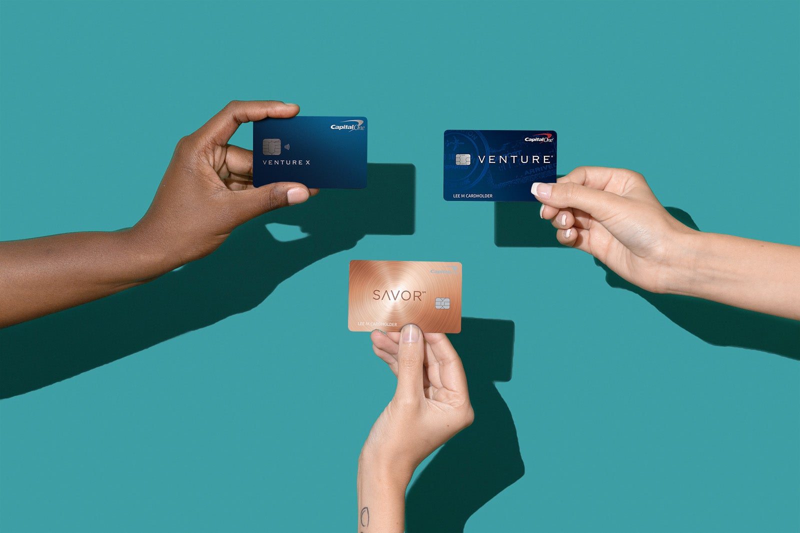 hands hold multiple Capital One credit cards