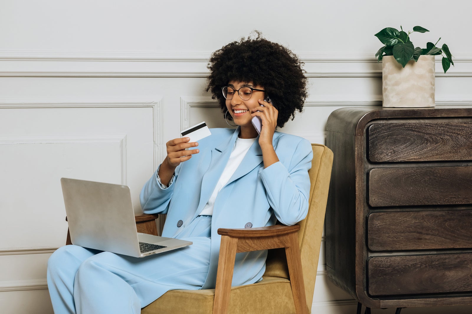 a woman has a laptop sitting on her lap while making a phone call