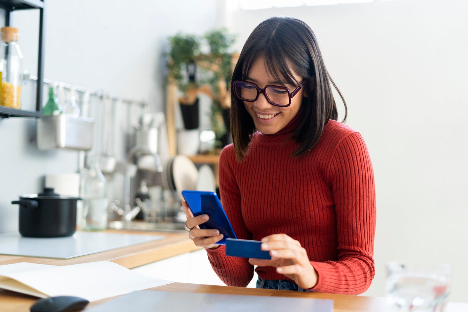 Woman holding her phone and a credit card