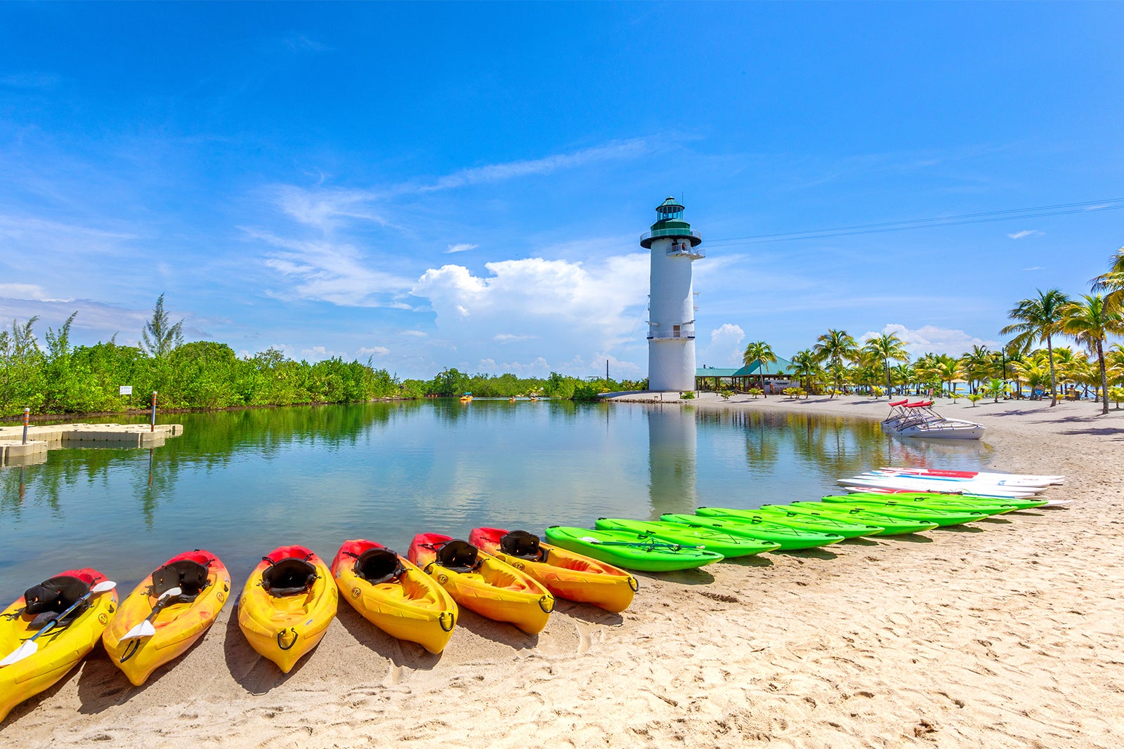 Line of kayaks along a beach in Harvest Caye, Belize