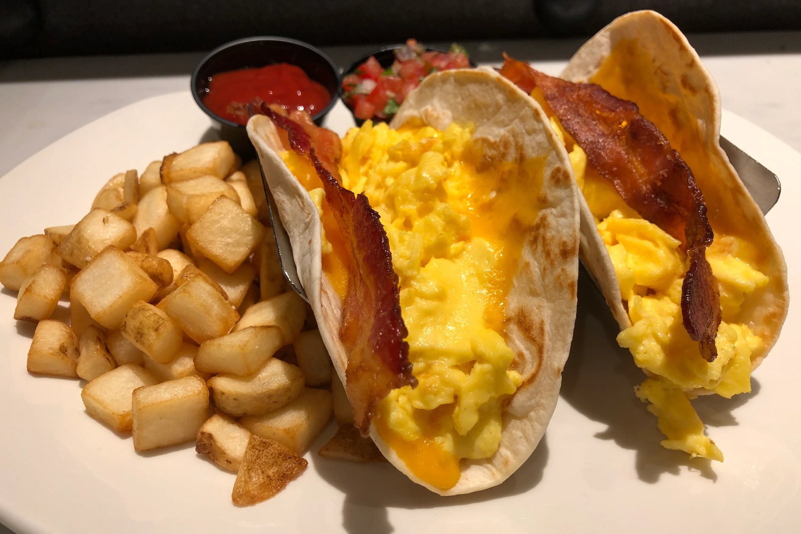 breakfast tacos and a side of potatos on a plate