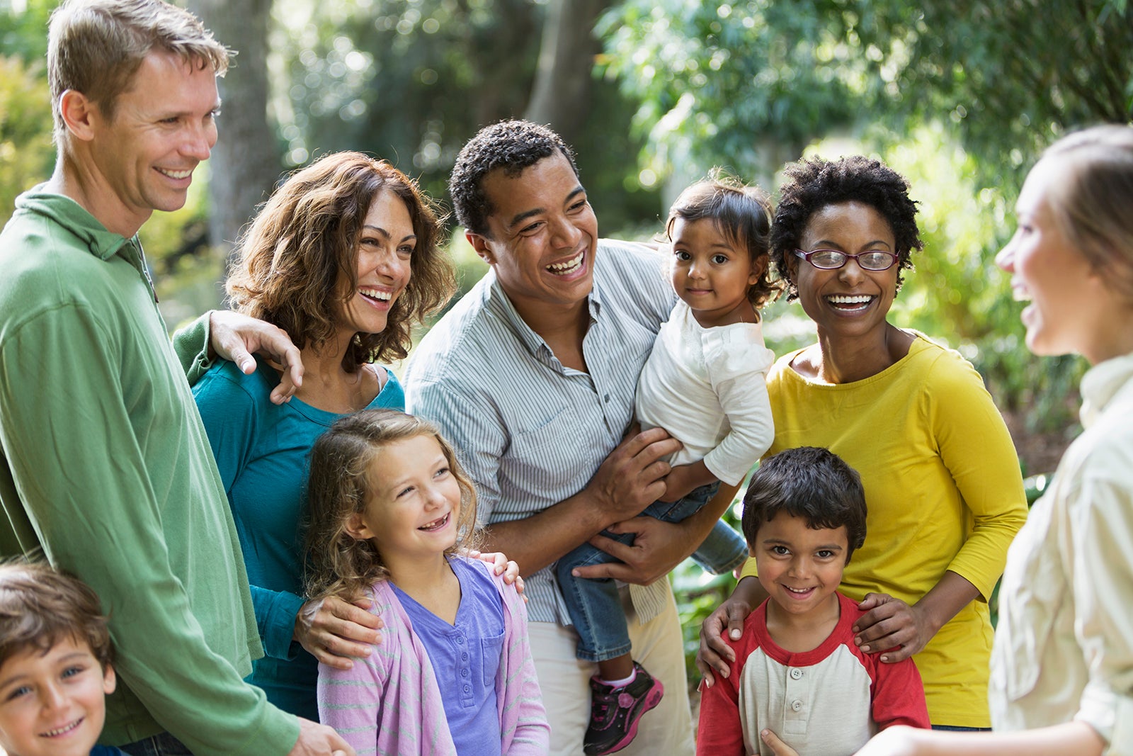 Multi-ethnic families at a park, talking with a tour guide.