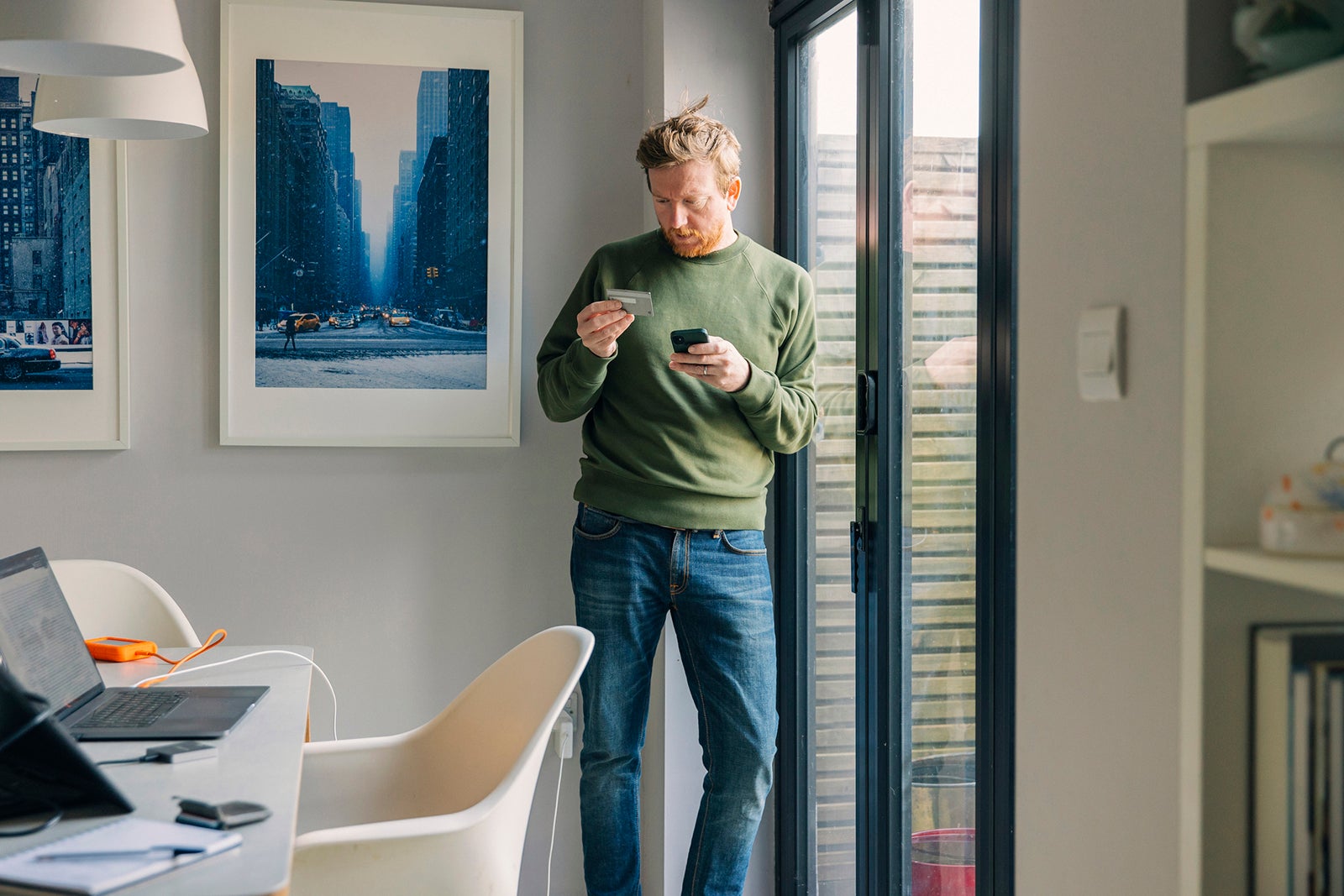 Man using a phone with a credit card