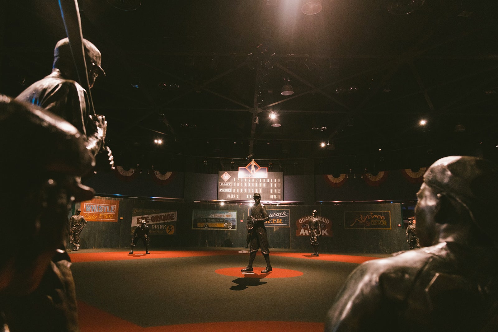 statues of baseball players in a dimly lit museum exhibit