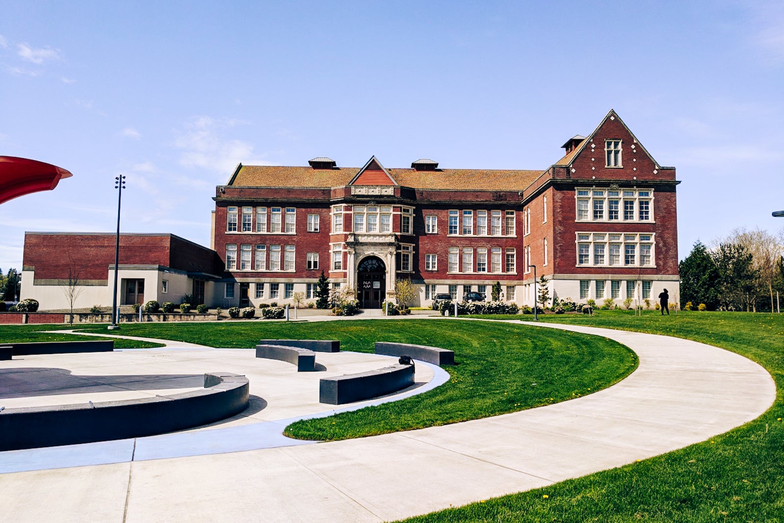 a red brick building surrounded by a green lawn