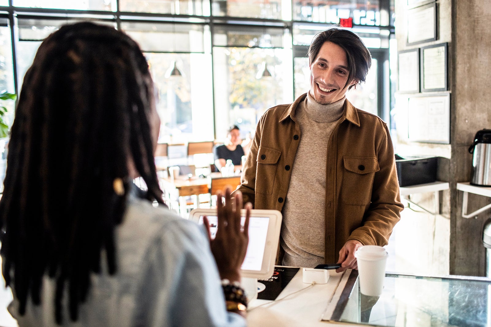 Man using a card at a coffee shop