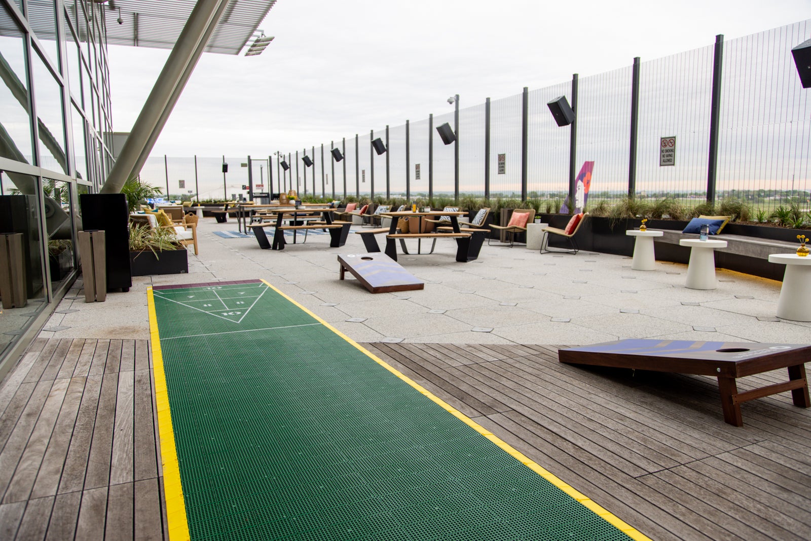 outdoor terrace with games of shuffleboard and cornhole (tossing rattles)