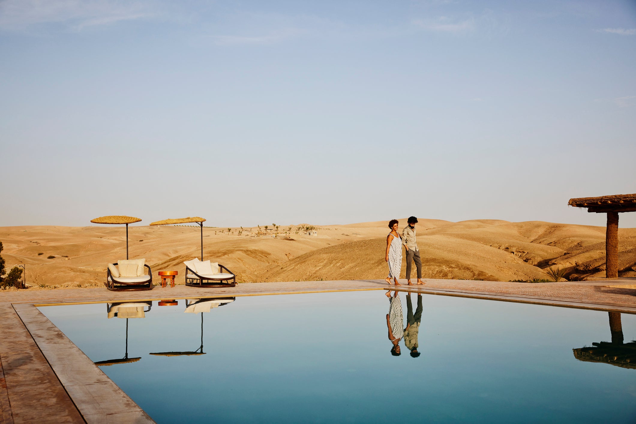 Couple walking around pool at Moroccan Desert Hotel Thomas Barwick