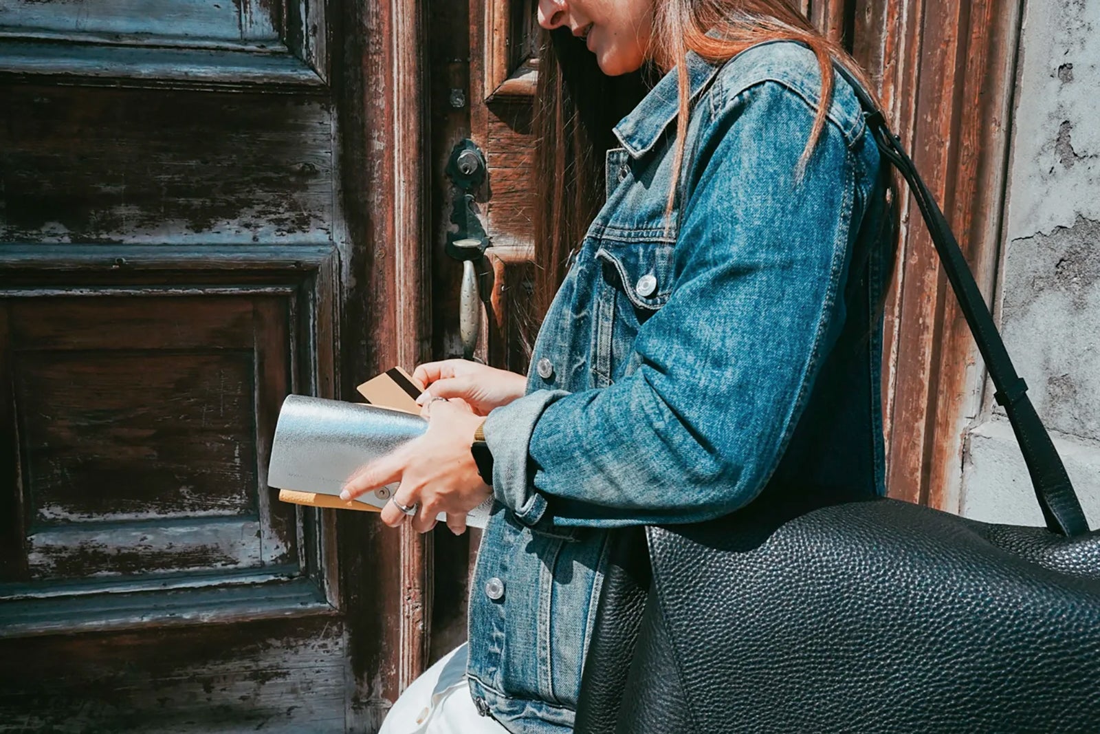 a woman holds a wallet with many credit cards