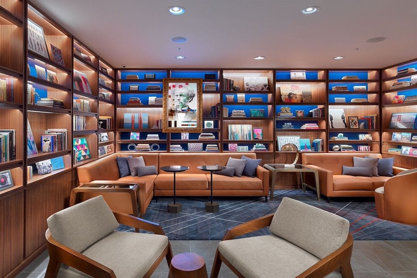 Chairs and tables in a colorful hotel lobby meets library setting