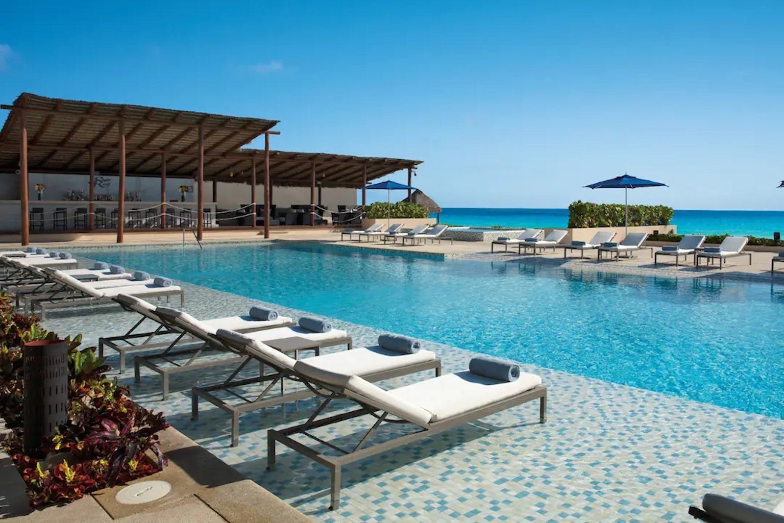 A hotel pool surrounded by empty lounge chairs
