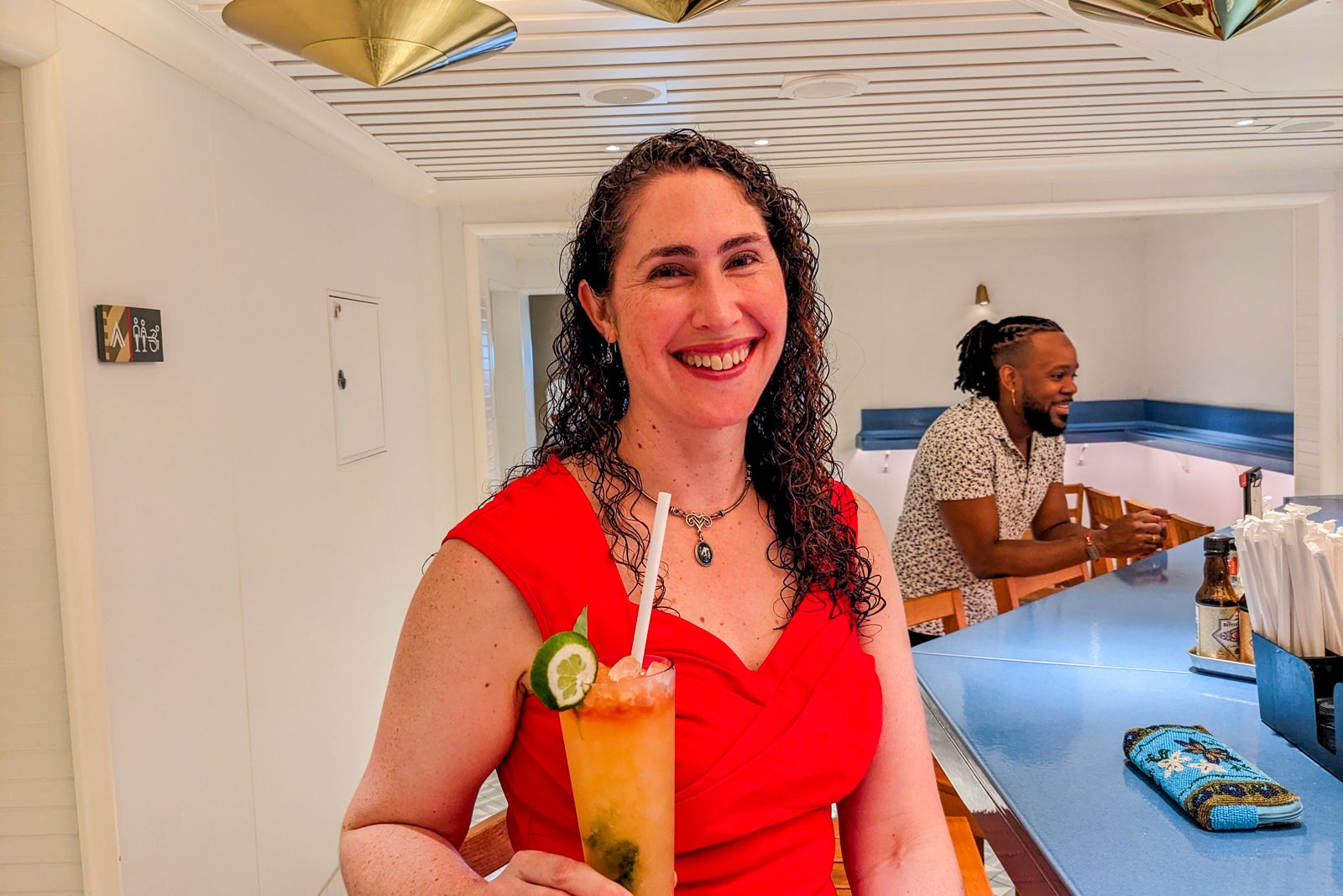 Woman in red dress at a bar with a cocktail