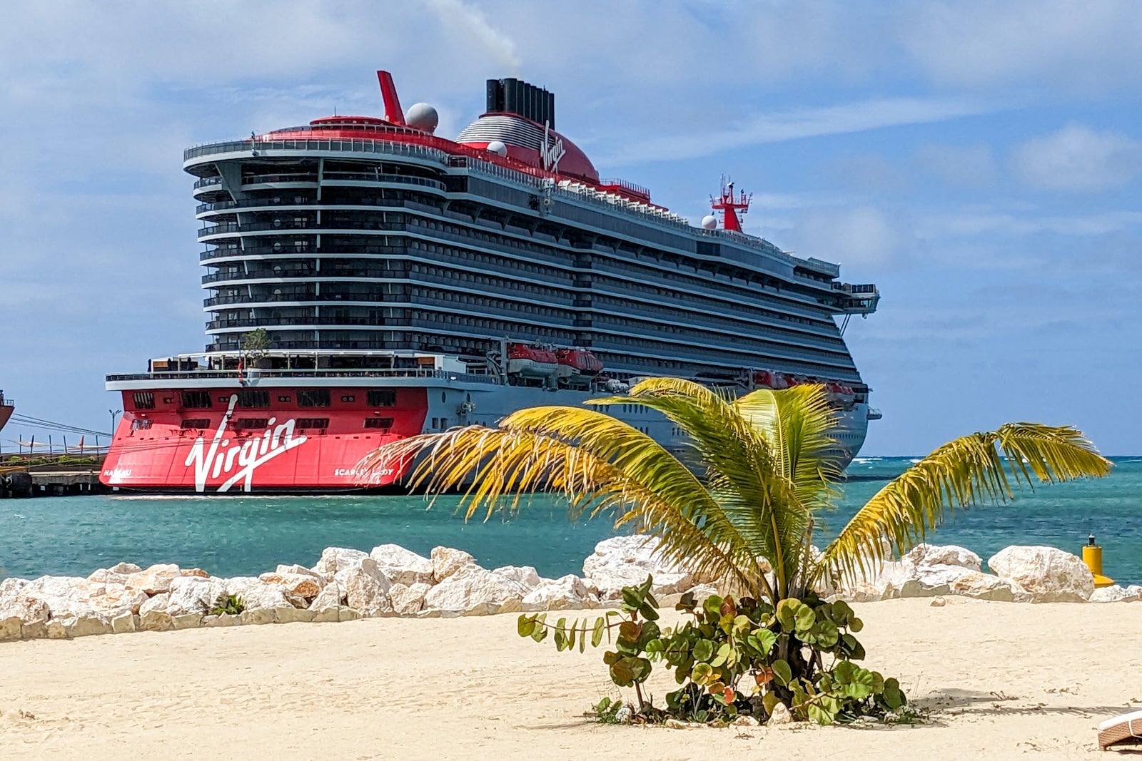 Scarlet Lady cruise ship docked with small palm tree in front