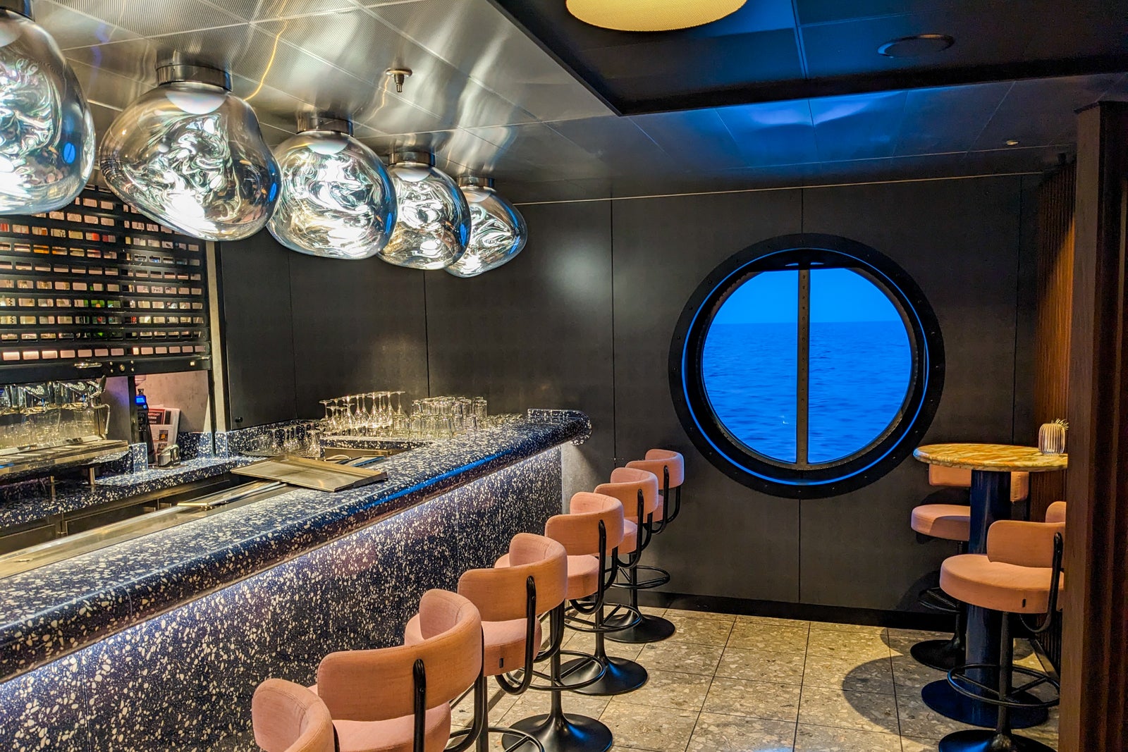 Bar with stools and porthole window on cruise ship
