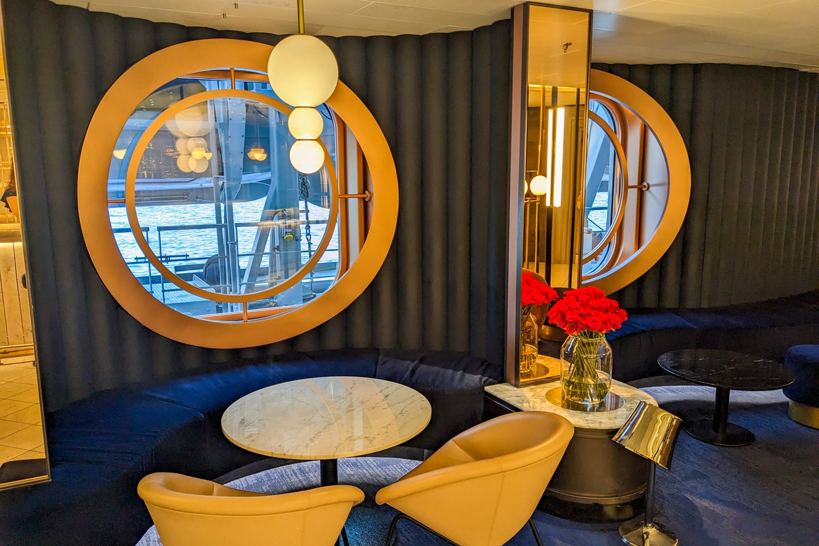 Lounge seating near porthole window on cruise ship