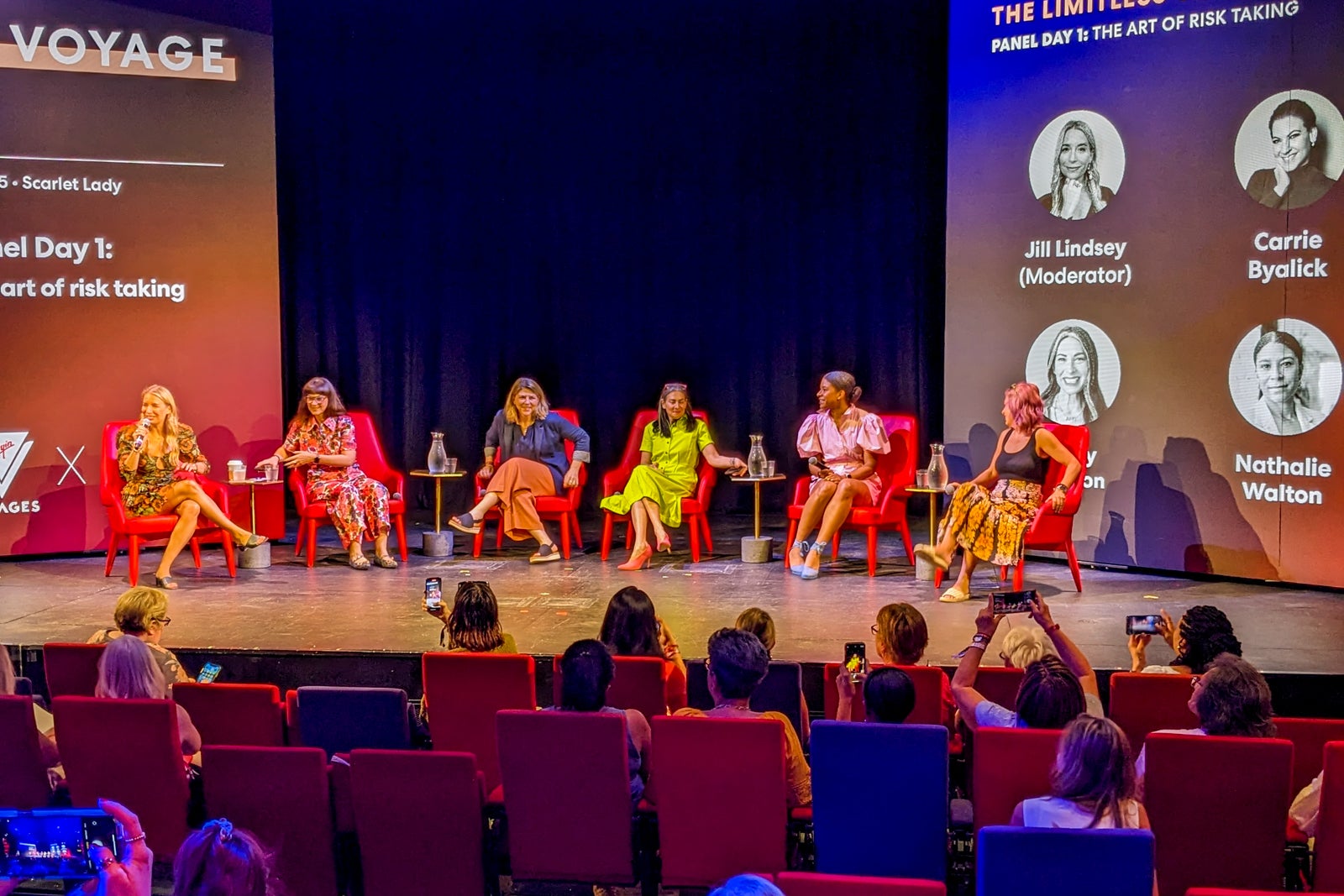 Five women sit on a stage during a panel session