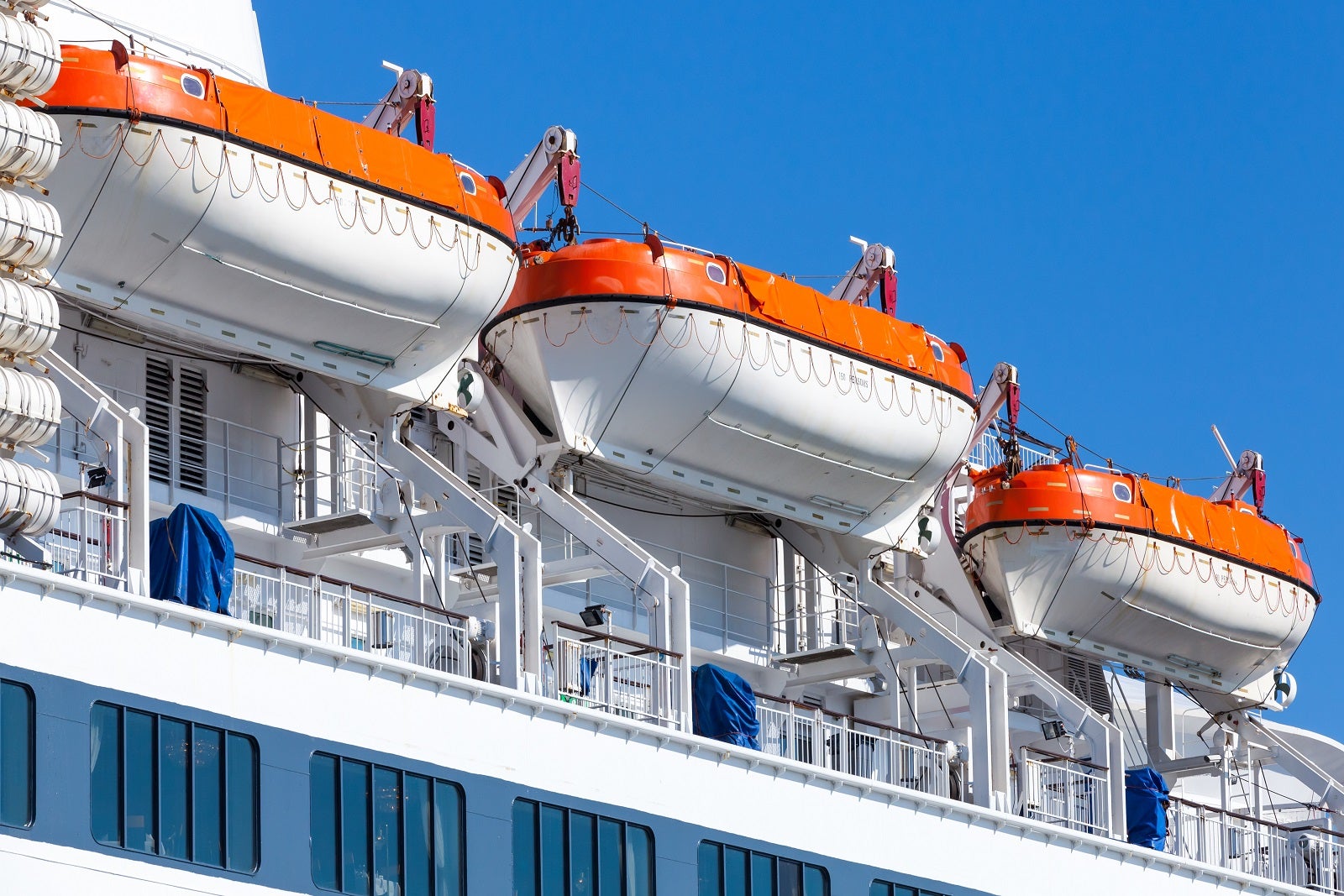 Lifeboats mounted on the side of a cruise ship