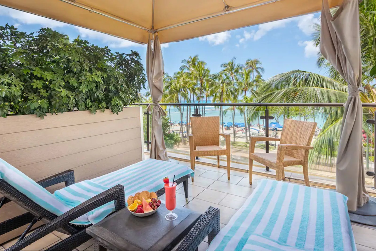 Loungers on a patio overlook the beach at the Hyatt Regency Waikiki Beach Resort in Hawaii