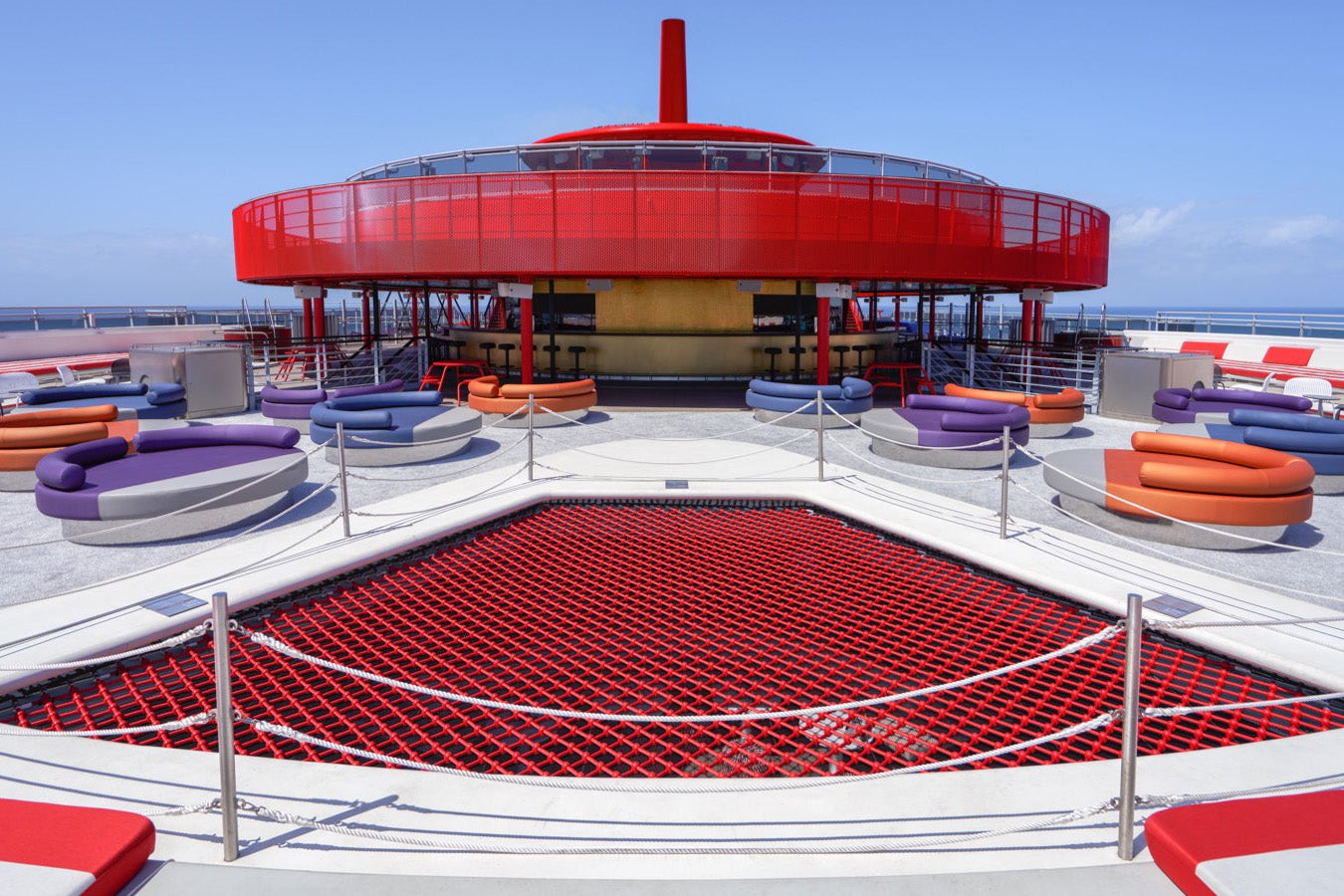 Red-roofed circular cruise ship bar with red netting in the foreground