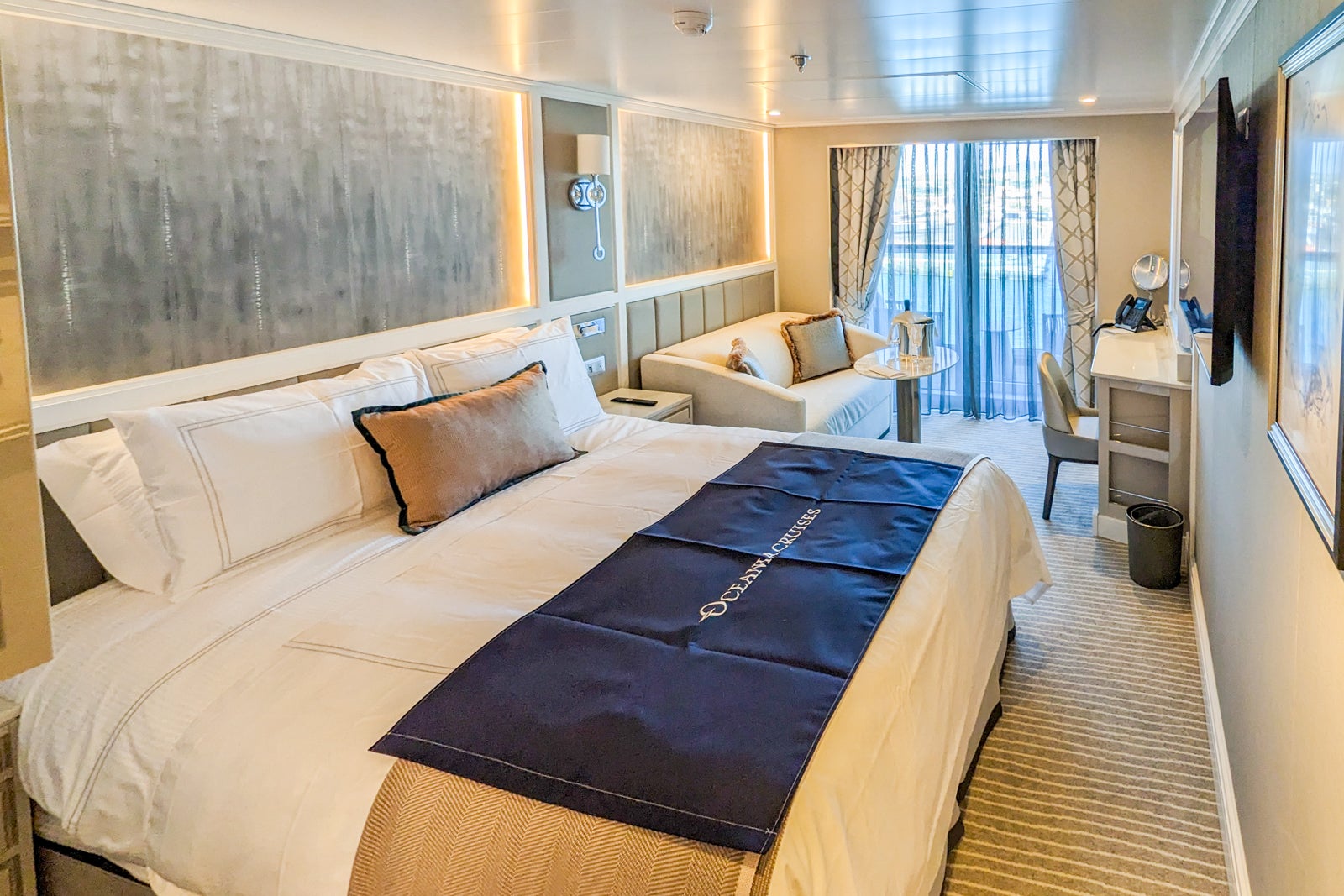 Oceania Cruises balcony cabin with double bed and white couch