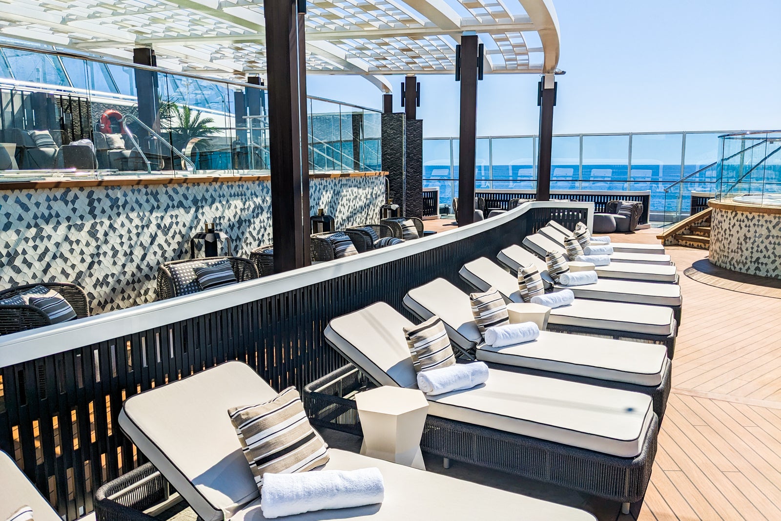 Rows of padded lounge chairs by thalassotherapy pool on a cruise ship