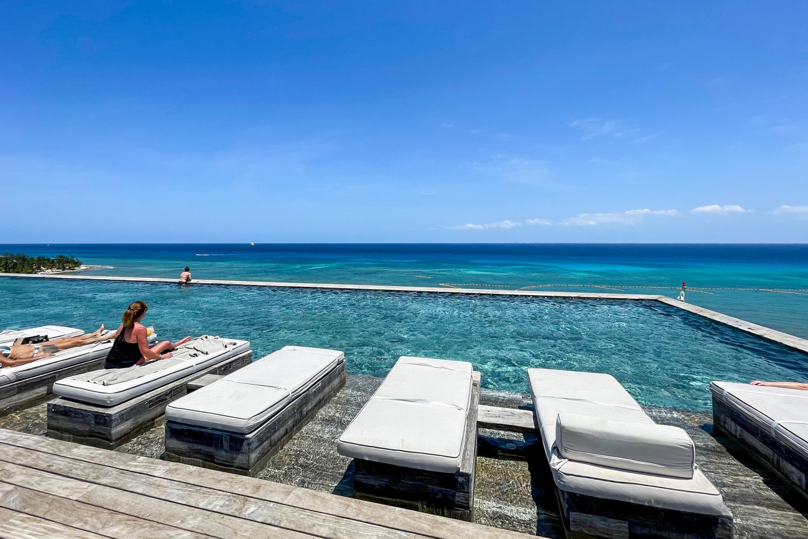 Sun beds overlooking infinity rooftop pool at Secrets Impression Moxche Playa del Carmen