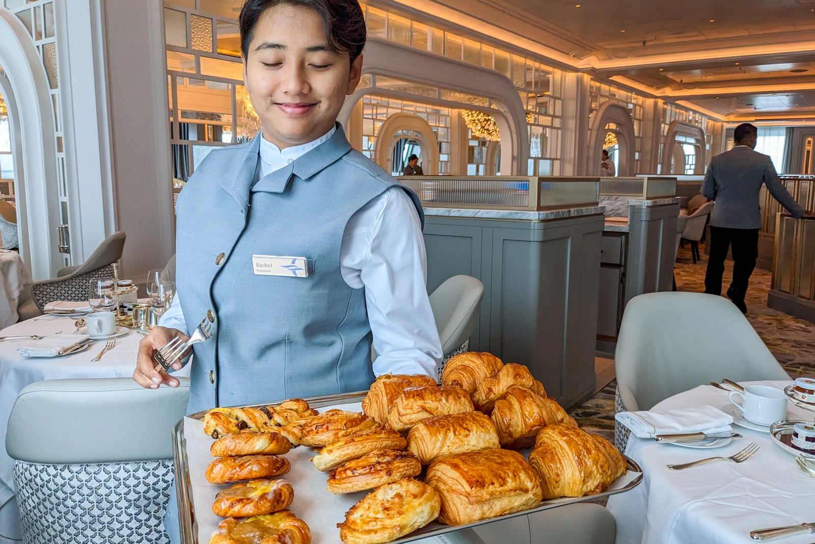 Waiter presenting tray of breakfast pastries