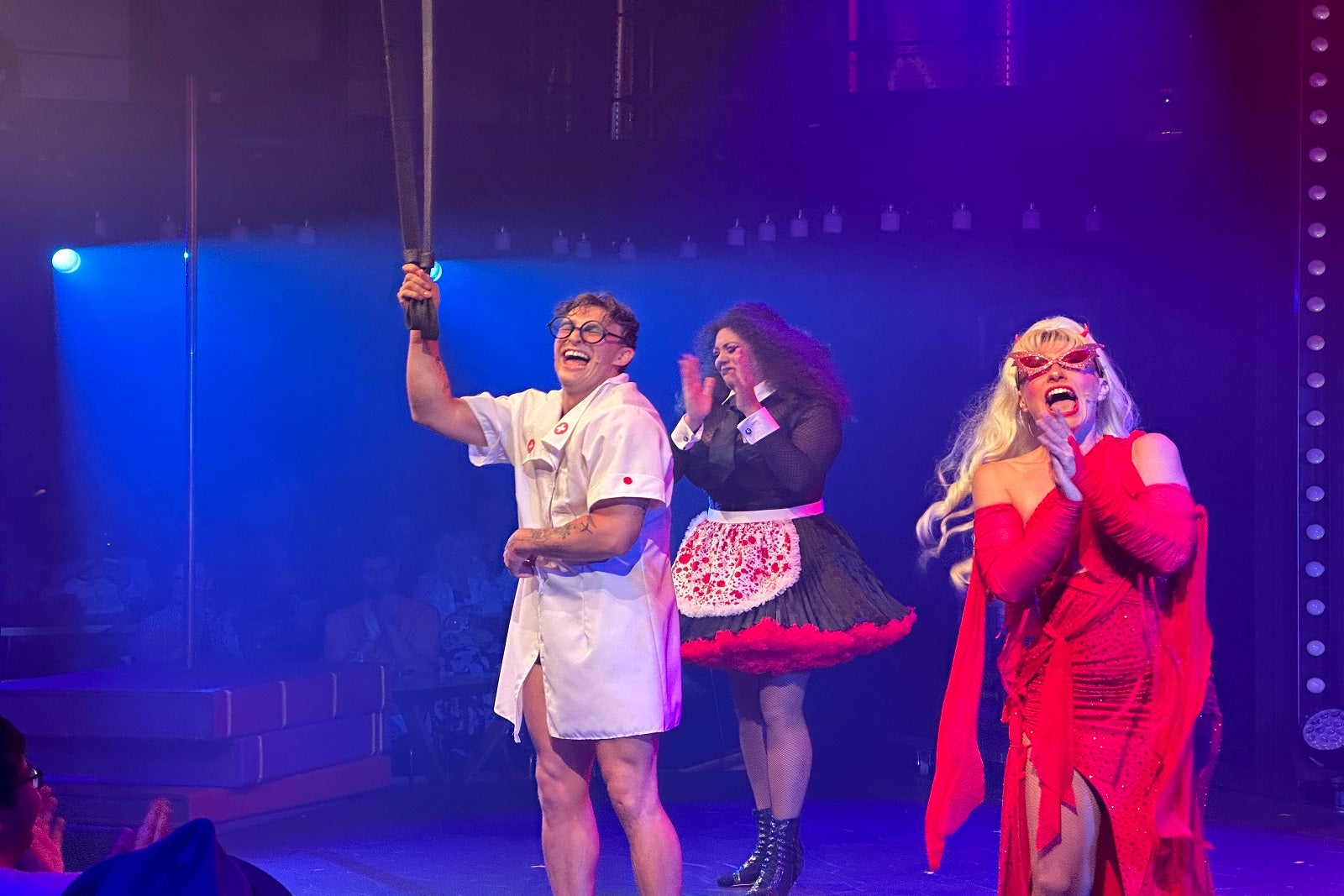 Cruise ship performers, one dressed as a nurse, one as a French maid and one in a red dress