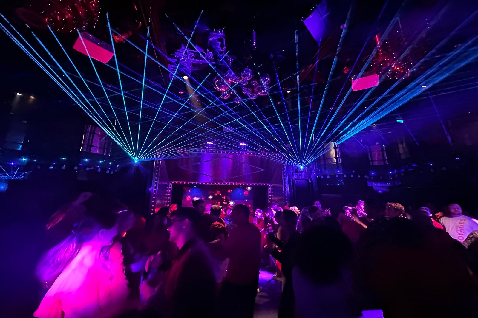 A party in a cruise ship nightclub with laser lights and a large crowd