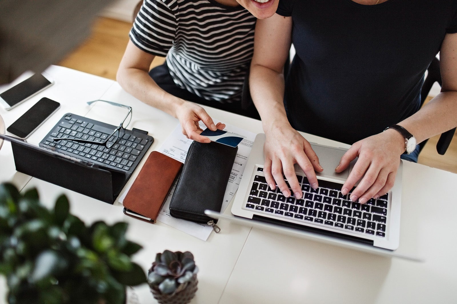 two people at computers with a credit card