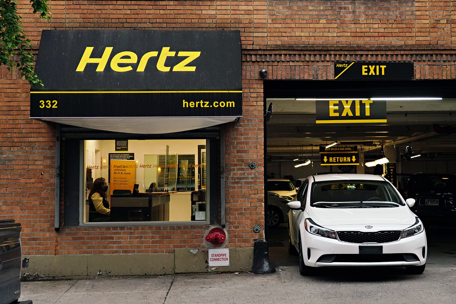 Hertz counter and white sedan