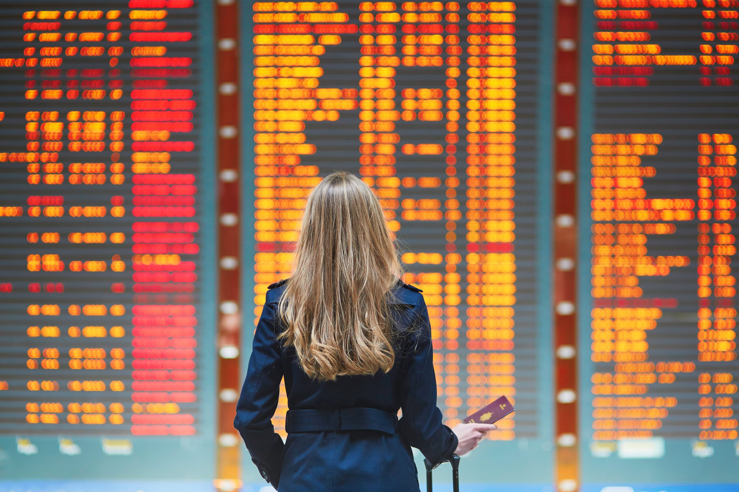 Traveler standing at flight delay signs