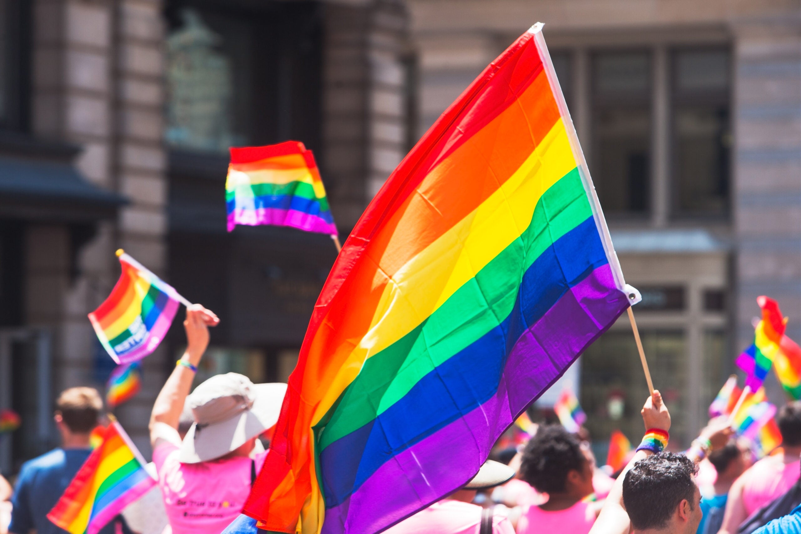 People waving Gay Pride flags at the Gay Pride Parade in New York City