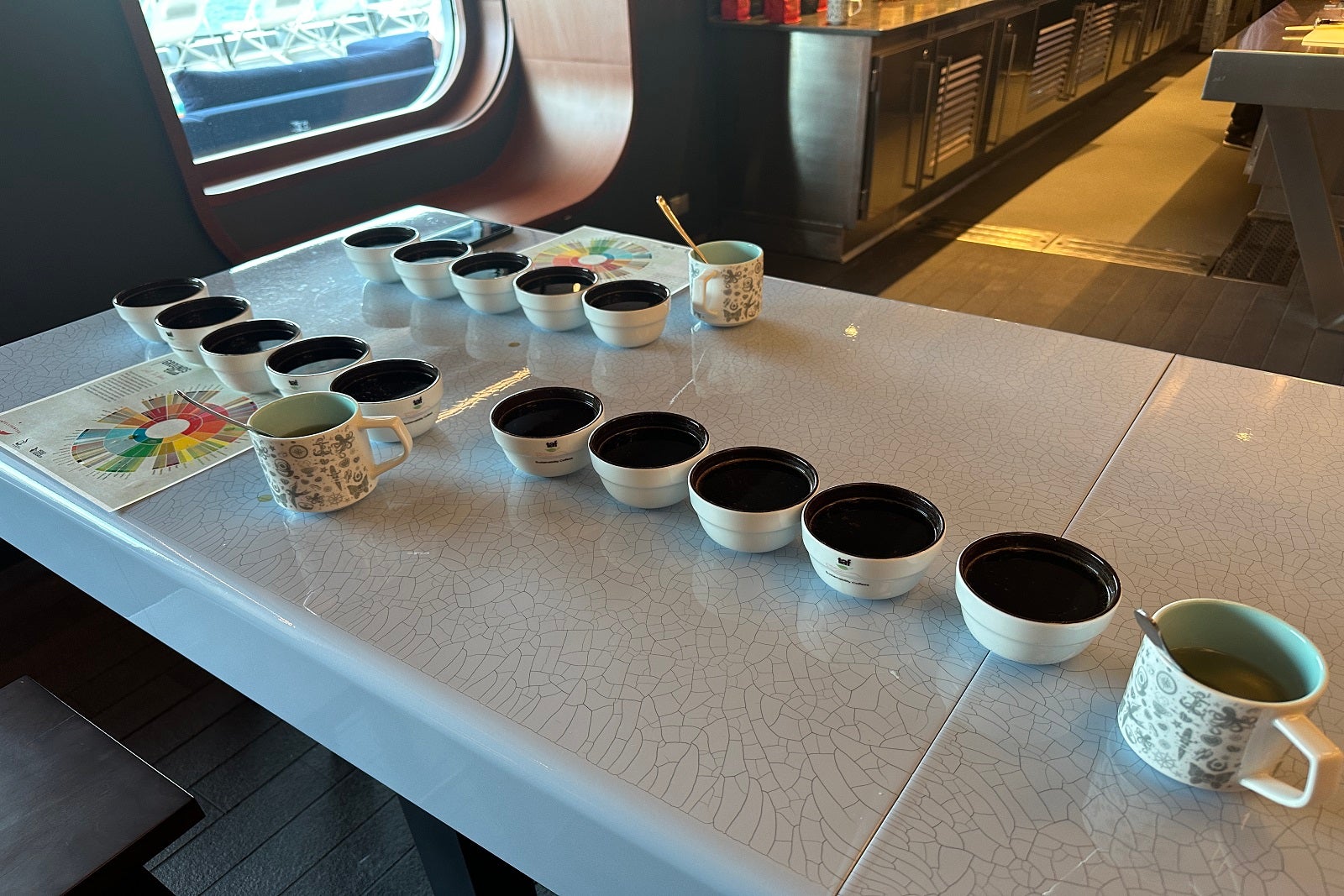 A row of small bowls holding coffee, along with several mugs