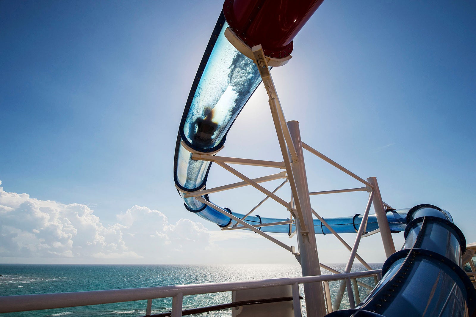 A clear waterslide on a cruise ship with a person sliding through it