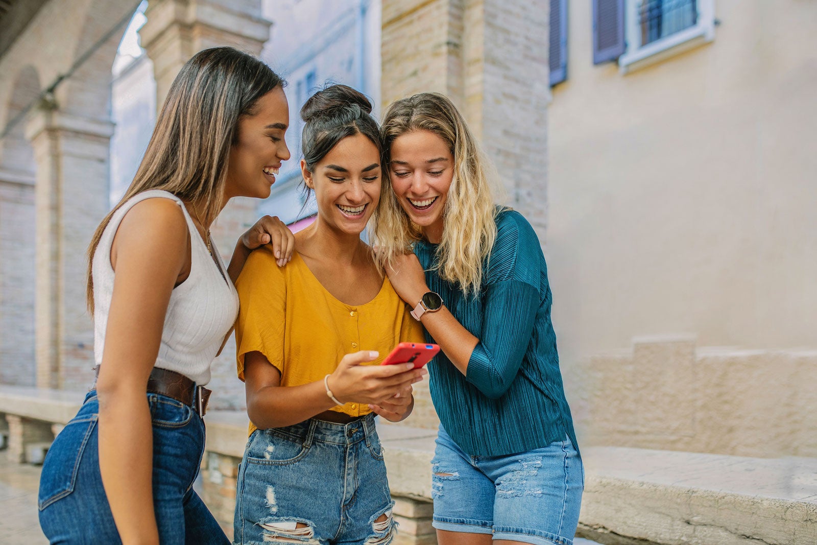 Friends looking at a phone together while traveling