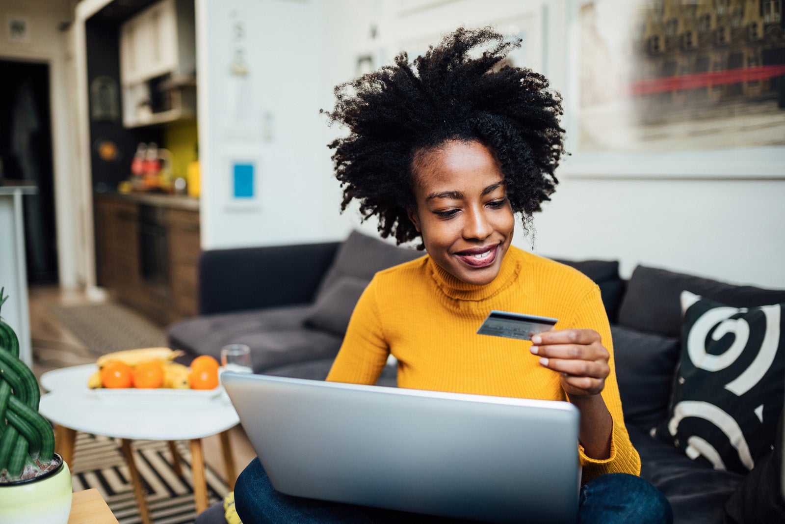 Woman using a laptop and holding a credit card