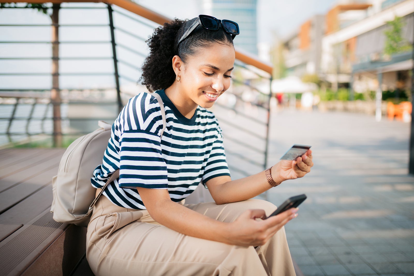 Happy young woman shopping online using a smart phone