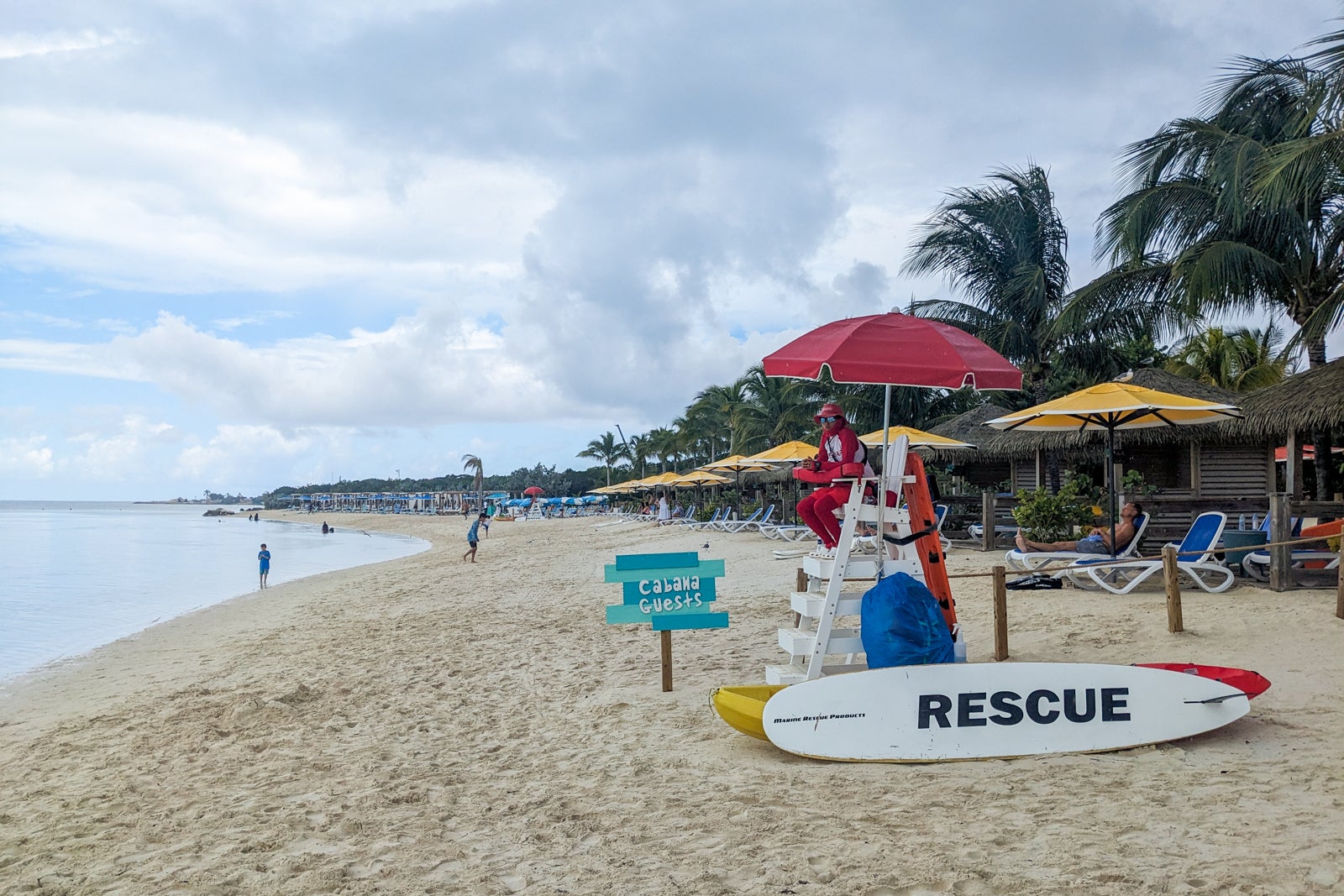 Lifeguard on beach by row of cabanas