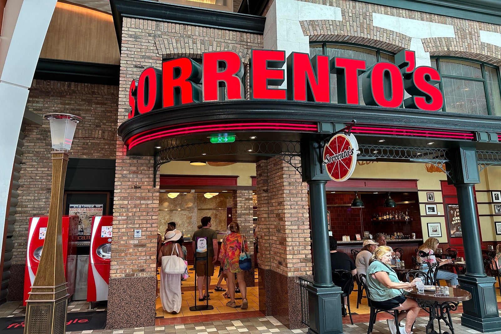 A brick pizza restaurant on a cruise ship with large red sign on the front that says 