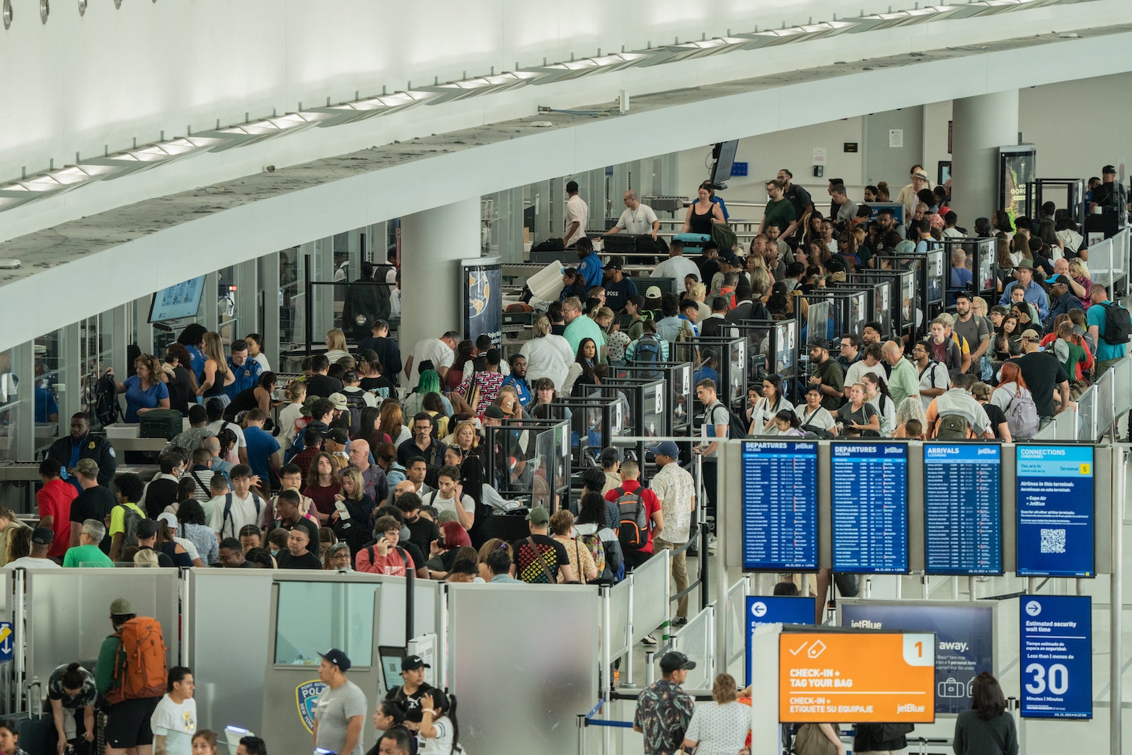 travelers wait to go through airport security