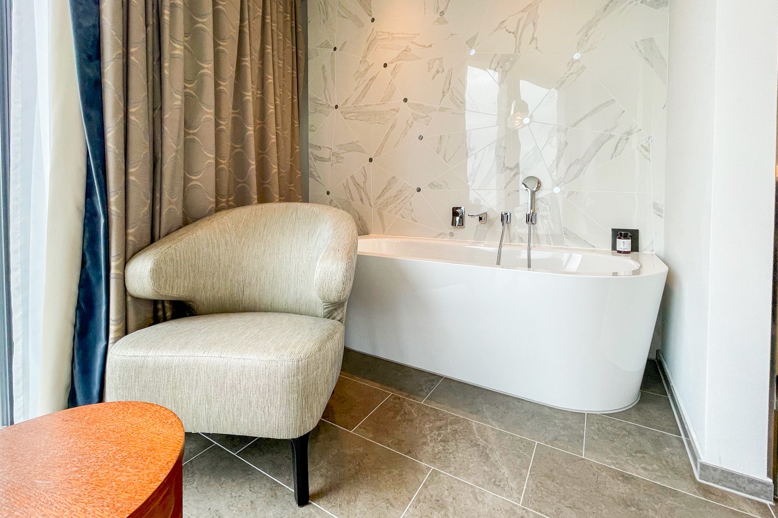 Armchair and table in front of the tub in the Andaz Vienna Executive Suite