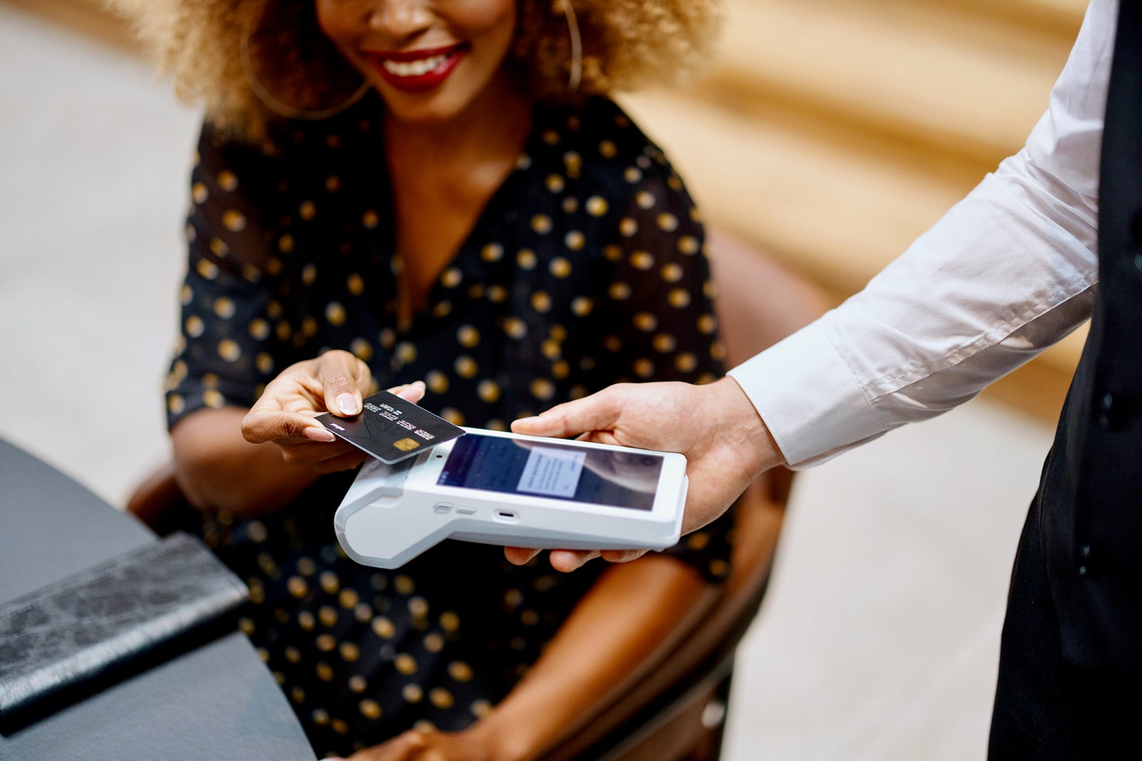 Businesswoman paying for the order contactless with a black credit card