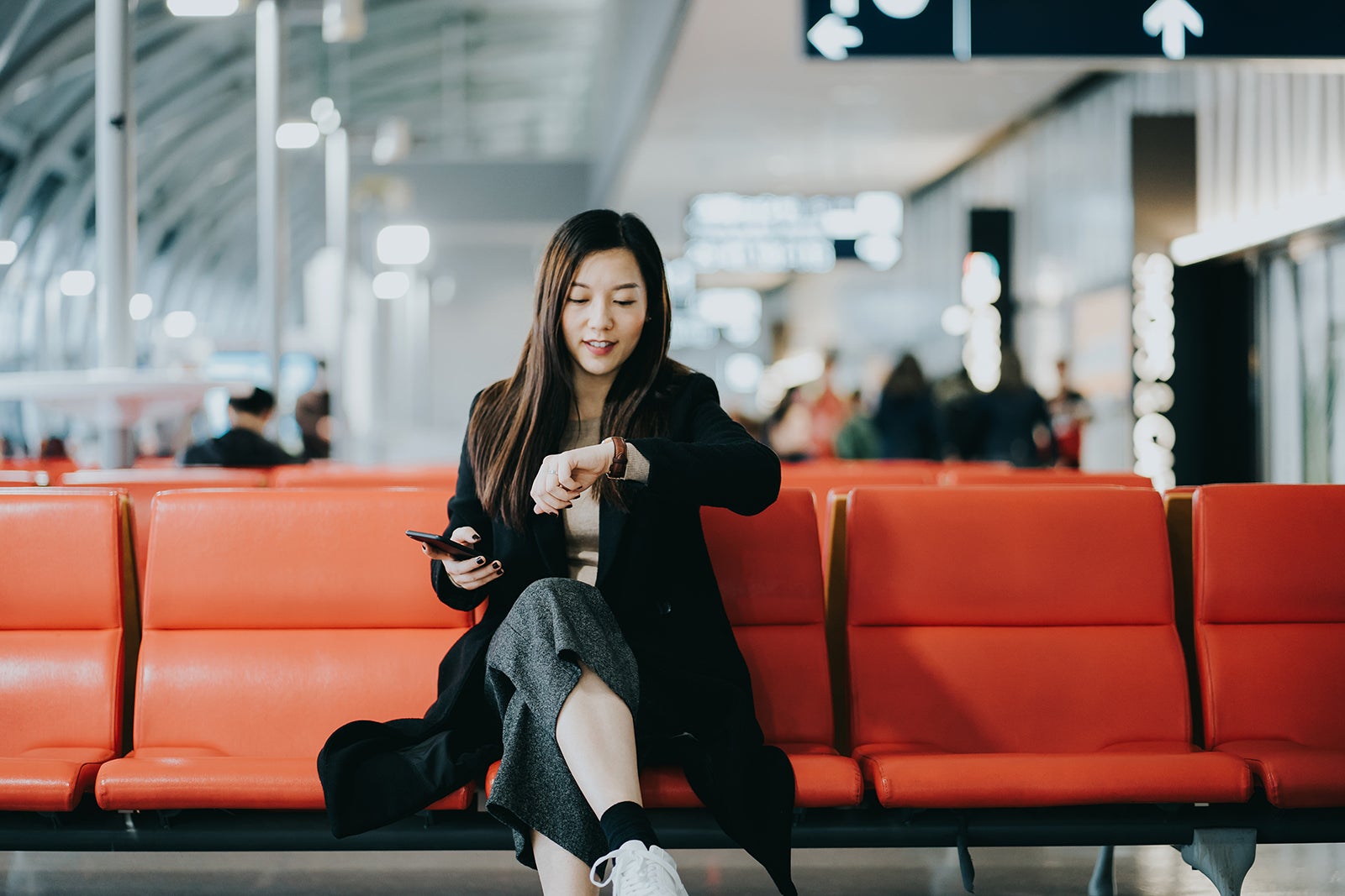 A young woman sitting on a chair in the airport