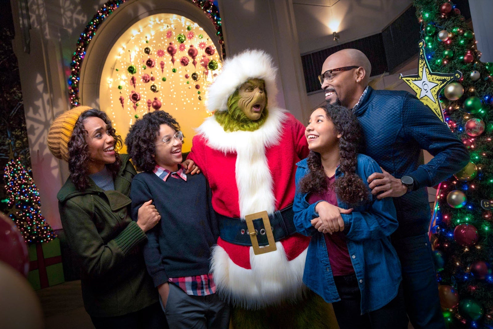 Family posing with the Grinch for a photo